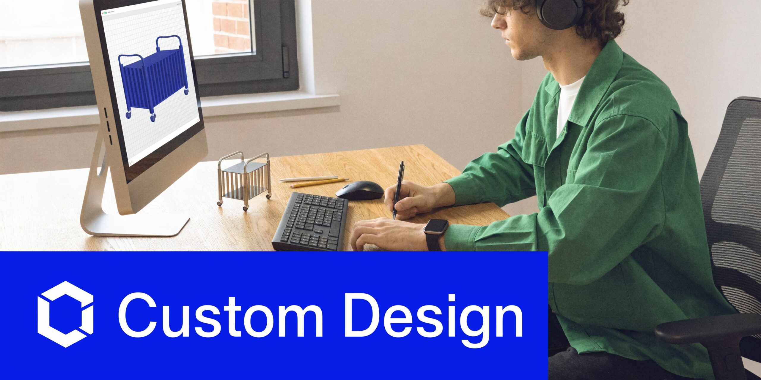 A professional designer wearing headphones works on a custom heavy-duty steel cart design using a computer.
